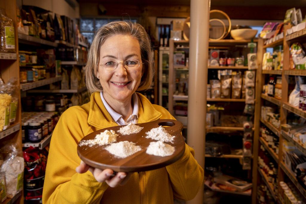 Monika Rosenfellner mit Tablett Mehl vor Regalen